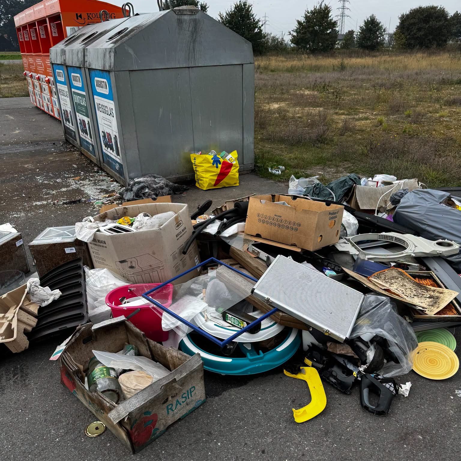 Kartons, Haushaltsgeräte, Plastiksäcke und Glasscherben liegen neben den Altglascontainern auf dem Asphalt