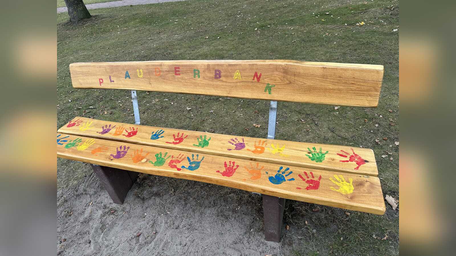 Die von Kindern bunt bemalte Plauderbank gegen Einsamkeit im Rathauspark Geeste