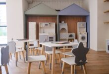 Spielküche mit kleinen Tischen und Stühlen in einem Gruppenraum