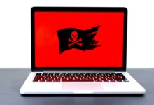 Laptop mit Totenkopf-Symbol auf rotem Bildschirm als Zeichen für einen Hackerangriff