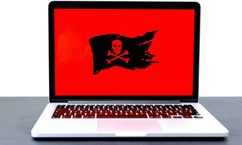 Laptop mit Totenkopf-Symbol auf rotem Bildschirm als Zeichen für einen Hackerangriff