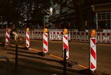 Straße mit rot-weiß gestreiften Absperrungen einer Baustelle