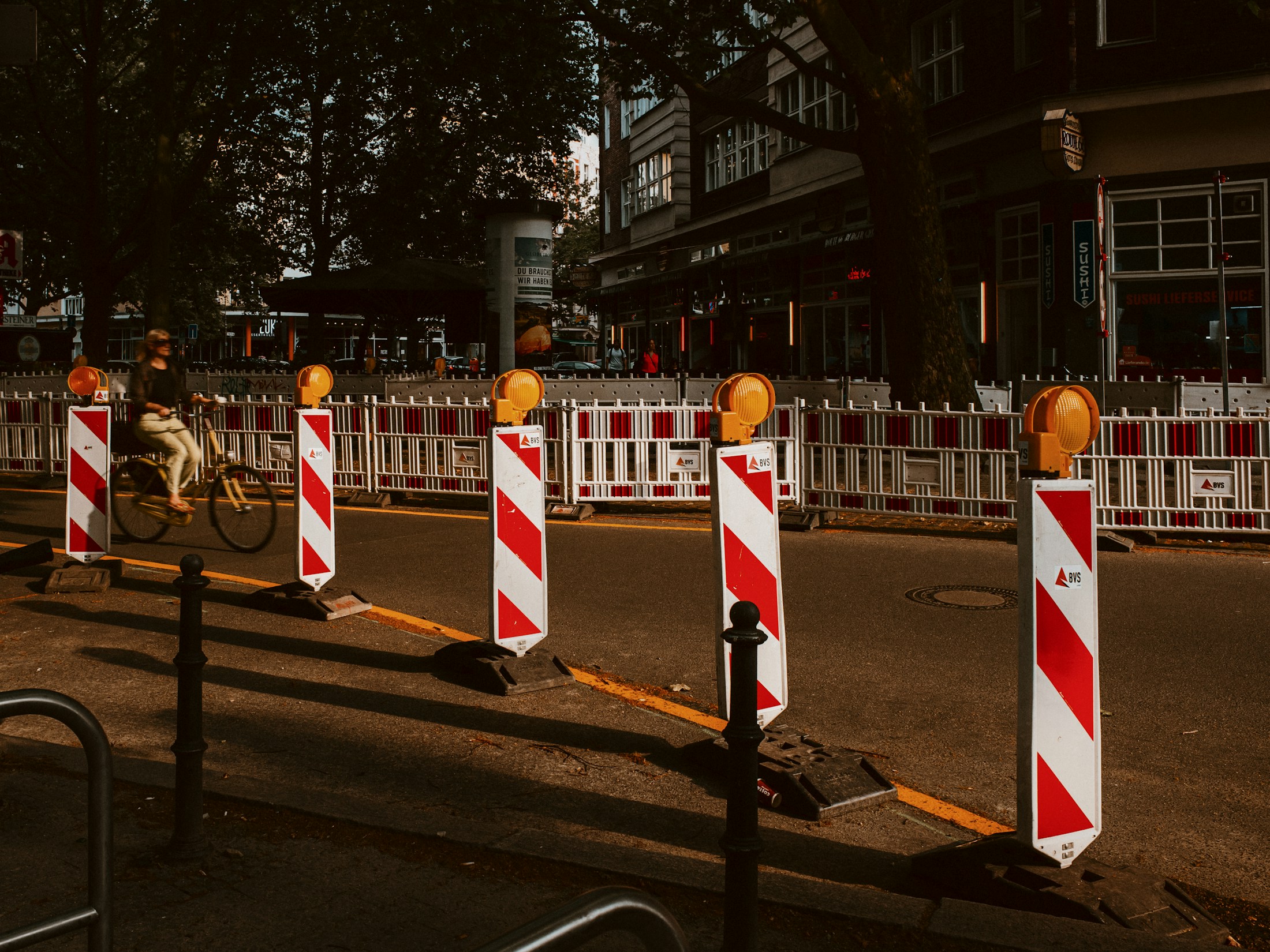 Straße mit rot-weiß gestreiften Absperrungen einer Baustelle