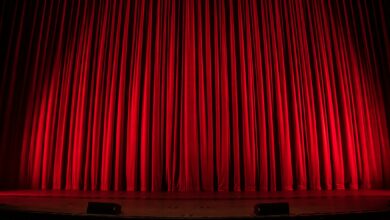 Publikum vor einer beleuchteten Theaterbühne