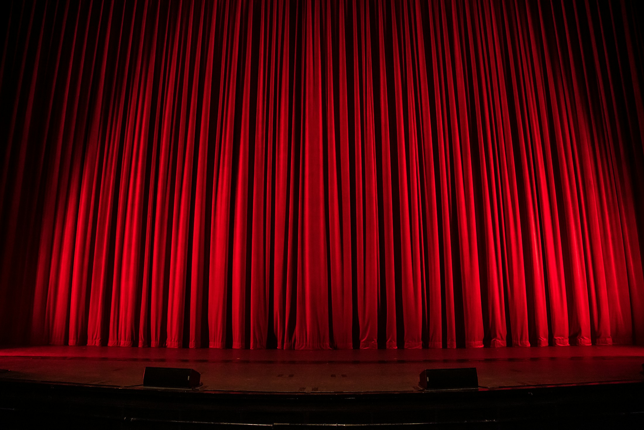 Publikum vor einer beleuchteten Theaterbühne