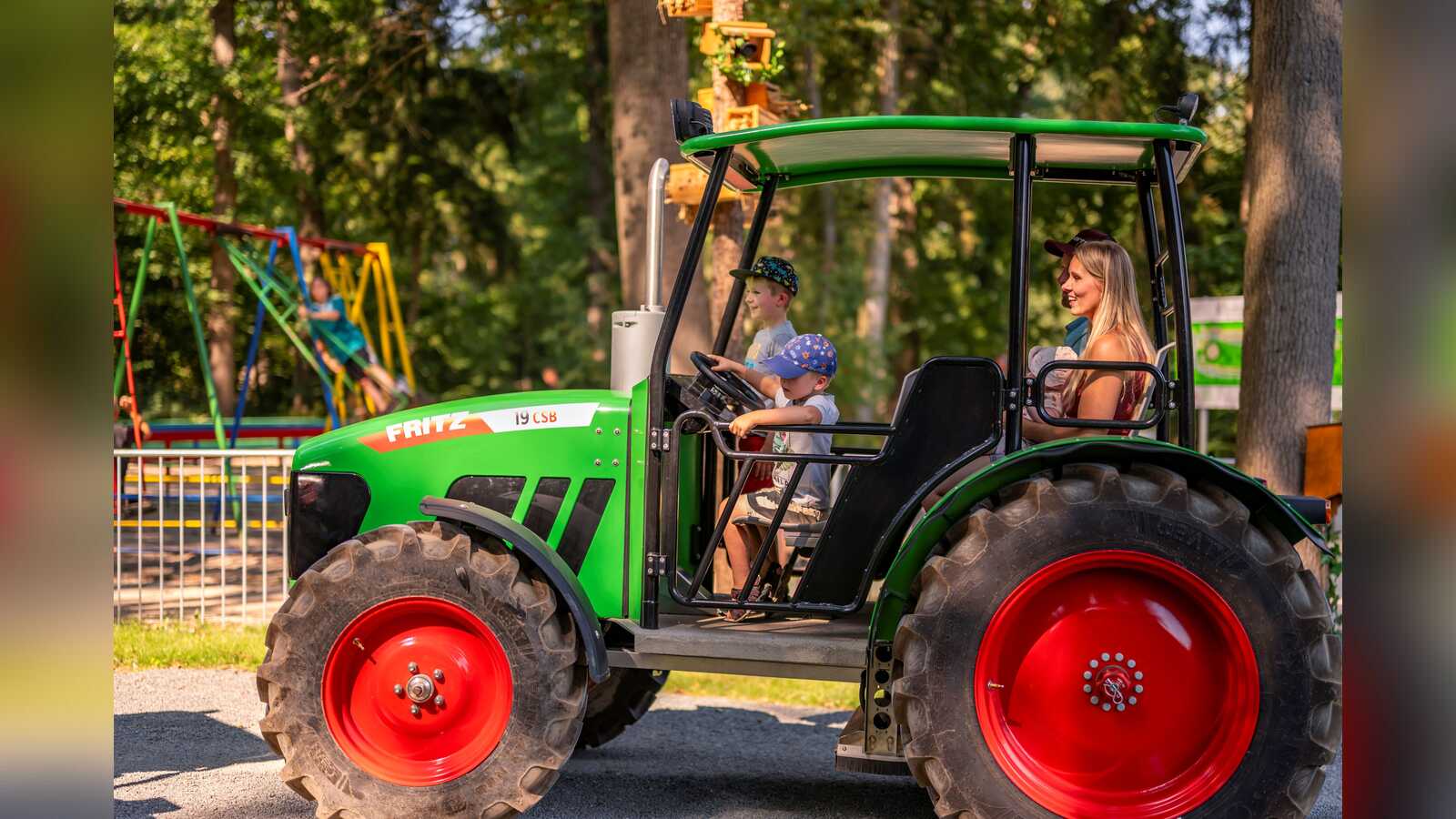 Kinder lenken einen Trecker auf der Treckertour im neuen Forsthof von Schloss Dankern