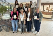 Acht Frauen stehen auf einer Treppe im Rathausfoyer und halten Wunschzettel in den Händen